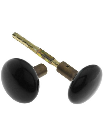 Pair of Black Porcelain Doorknobs with Brass Shank in Antique Brass.
